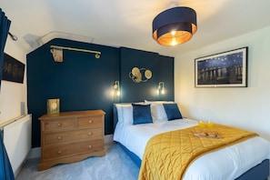 Un dormitorio con cama, cómoda y obras de arte en la pared.