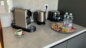 A kitchen counter with a coffee maker, a kettle, a toaster, and two water bottles. - Casa Albenga  (Albenga)