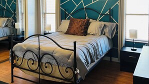A modern bedroom with a geometric-patterned wall, a bed with a metal frame, and a ceiling fan. - Charming 3-bedroom house with AC, WiFi in phenomenal Phoenix (Phoenix)