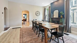 A dining area with a long wooden table, black chairs, and a patterned rug. - Beautiful 3BR/2.5 BTH PERFECT location in Short North/Campus w/HUGE 4 car garage (Columbus)