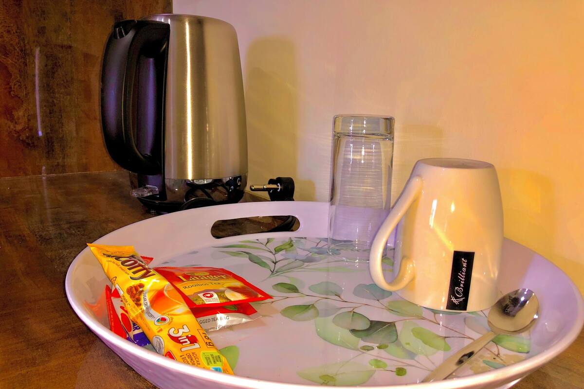 Una encimera de cocina con una bolsita de té, una taza y una tetera.