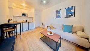 Un appartement moderne comprenant une cuisine, un coin repas et un salon.