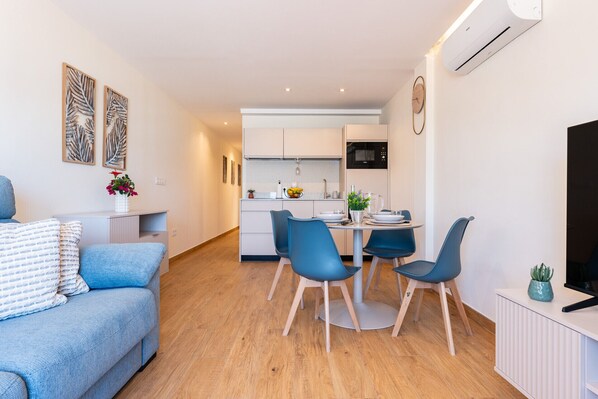 Un apartamento moderno con sala de estar, comedor y cocina.