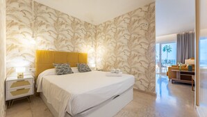 Une chambre d’hôtel avec un grand lit, une table de chevet avec une lampe et une vue sur le balcon.