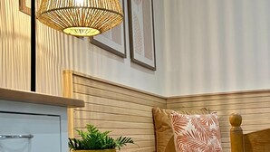 A corner seating area with a bench, a small table with a potted plant, and a wall-mounted lamp.