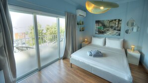 A bedroom with a large bed, a balcony, and a view of a building. - Stylish, large 3bedroom, seafront terrace GOSLM-13 (Sliema)