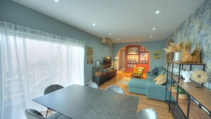 A modern living room with a dining area, a sofa set, and a bookshelf. - Stylish, large 3bedroom, seafront terrace GOSLM-13 (Sliema)
