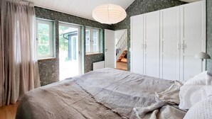 Una camera da letto con un letto grande, una scala e vista sull'esterno.