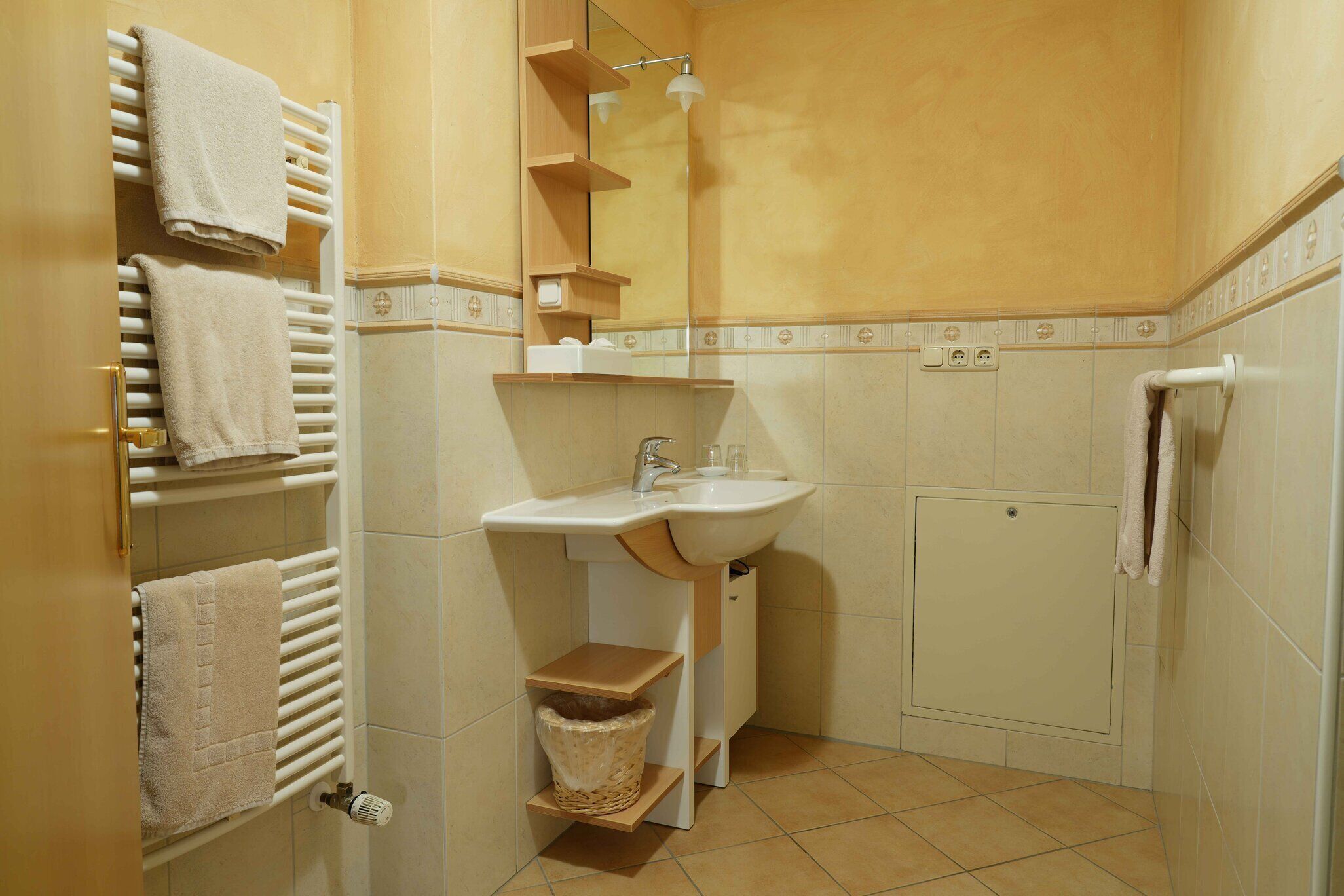 Une salle de bain équipée d’un lavabo, d’un porte-serviettes et d’un espace douche.