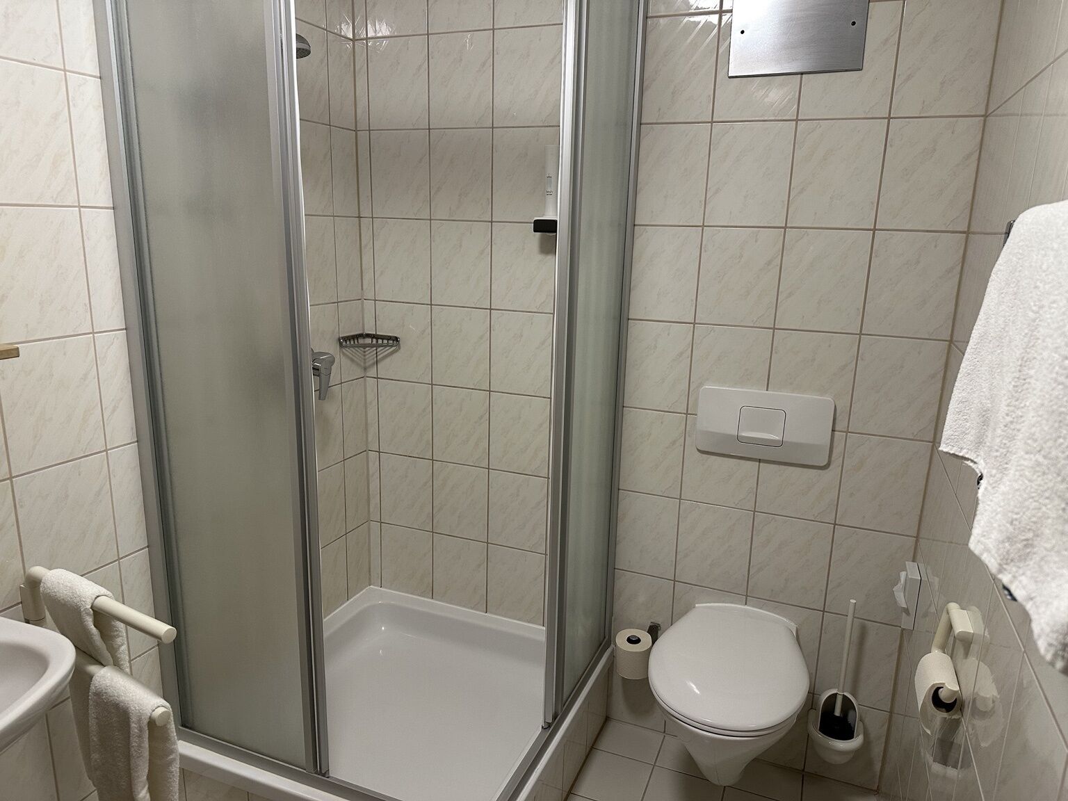 Une salle de bain avec une douche à parois de verre, des toilettes et un lavabo.