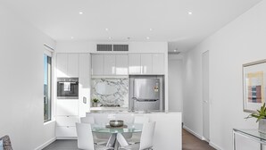 A modern kitchen with white cabinets, a marble backsplash, and stainless steel appliances. - Swainson on Hindmarsh (Adelaide)