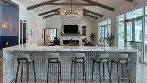 A spacious bar area with a high ceiling, exposed beams, and a large chandelier. - King Condo In Panama City Beach Resort Amenities Hot Tub Downtown Pier Park (Panama City)