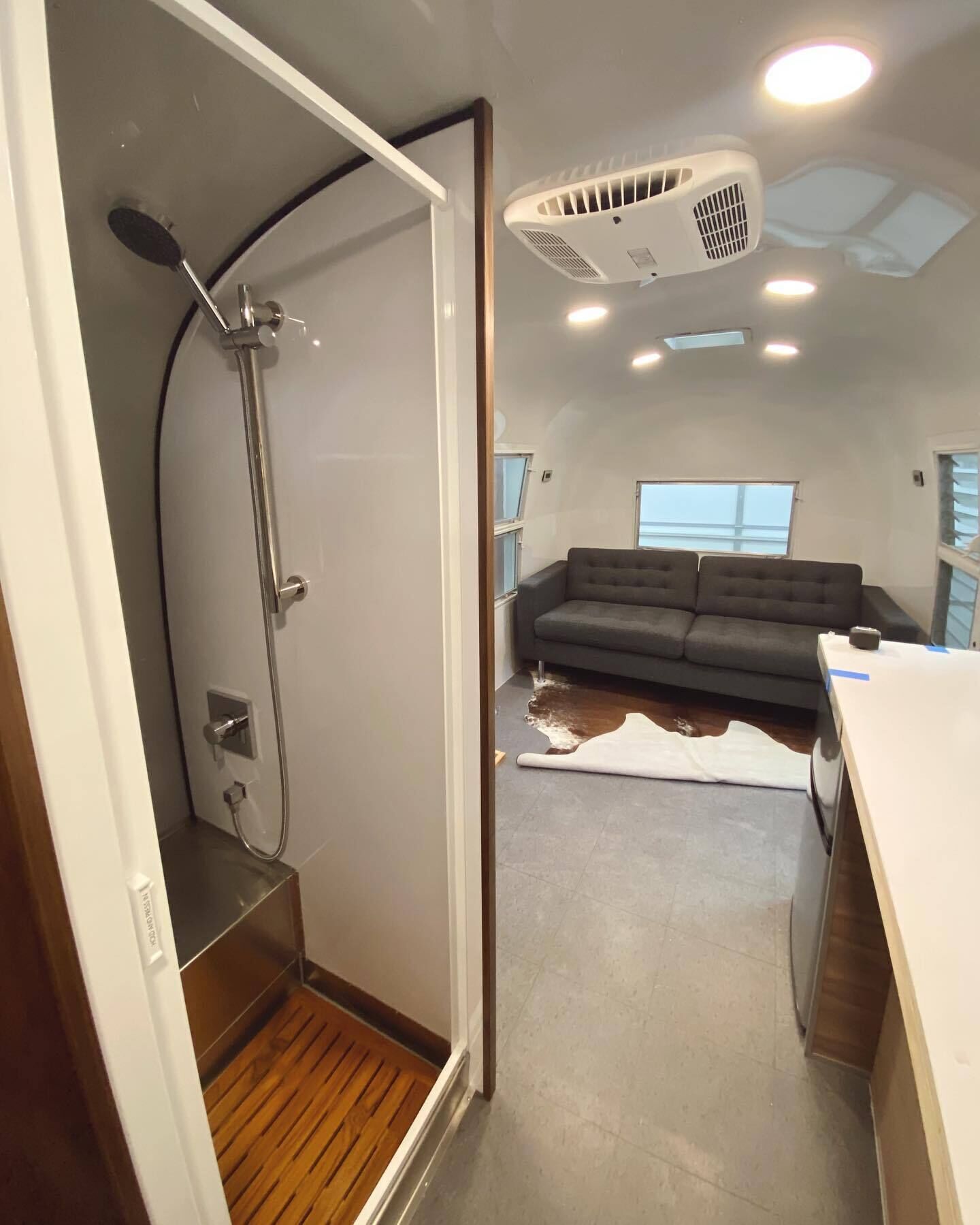 Een modern interieur met een douche, een bank en een plafondventilator.