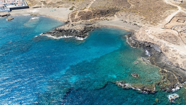 An aerial view of a coastal area with clear blue waters, rocky outcrops, and a sandy beach. - Home2Book Orballo Sea Views Apt, Terrace&Pool (Abades)