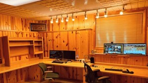 A wooden-paneled room with two desks, two chairs, and multiple computer monitors. - Beautiful Four-Level Split Home @ Calm Cul-de-sac! (Roseville)