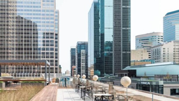 A rooftop terrace with outdoor seating, surrounded by high-rise buildings. - Beautiful Four-Level Split Home @ Calm Cul-de-sac! (Roseville)
