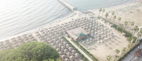 Privatstrand, Sonnenschirme, Strandtücher, Volleyball