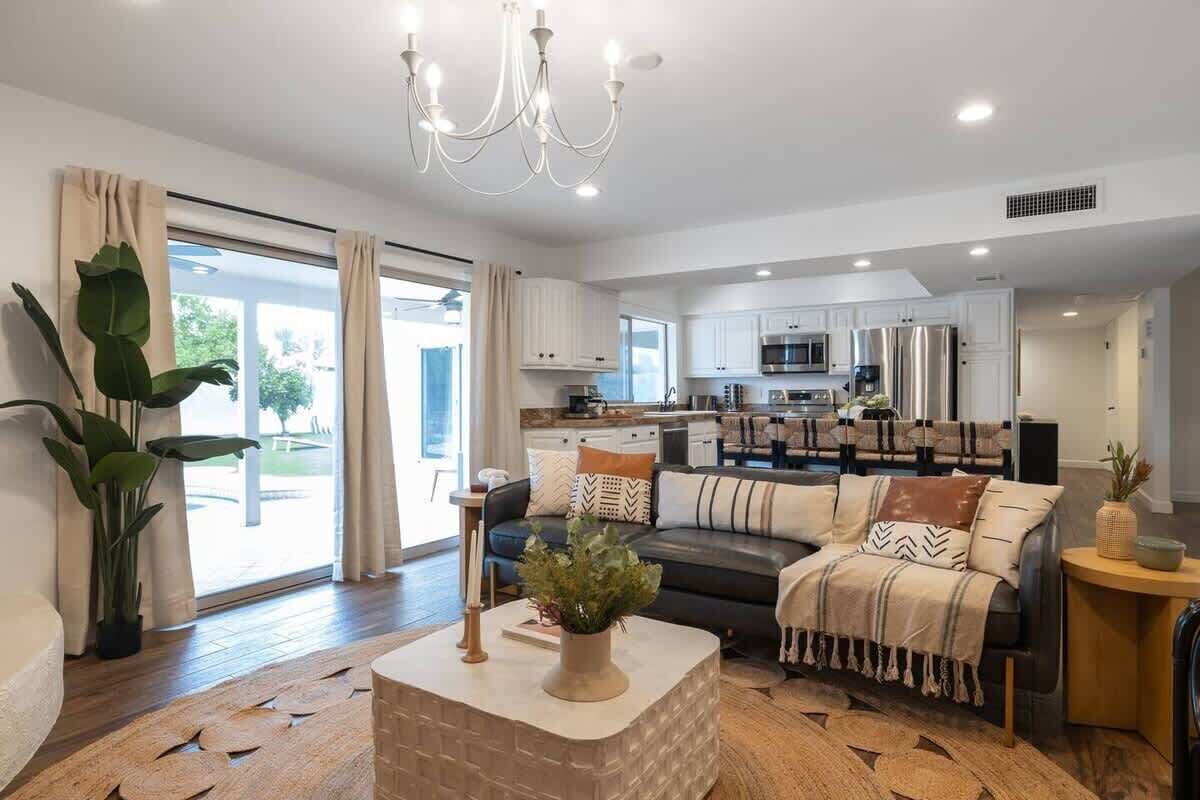 A modern living room with a sofa, coffee table, and potted plants.