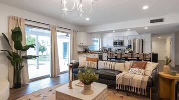 A modern living room with a sofa, coffee table, and potted plants.