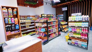 A modern retail store with wooden shelves stocked with various products, a checkout counter, and hanging plants. - Comfy Apartment-Pool & Gym in Kilimani- Nairobi Near National Park (Nairobi)