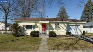 A single-story house with a front door, a small porch, and a garage.