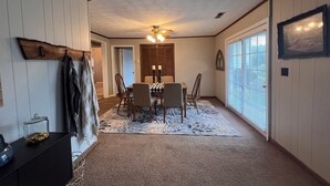 A dining area with a table and chairs, a ceiling fan, and a window with blinds.