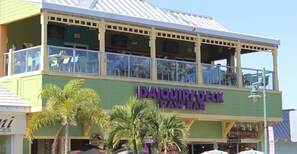 A two-story building with a sign for "DAQUIRI DECK RAW BAR".