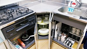 A compact kitchen with a gas stove, a sink, and built-in storage for dishes and utensils. - -Takaya house- Minamirokugou close Haneda AP (Ota City)