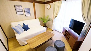 A cozy room with a sofa, a wooden bench, a television, and a plant. - -Takaya house- Minamirokugou close Haneda AP (Ota City)