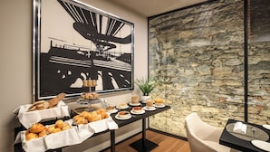 Une table de buffet garnie de divers plats et une grande œuvre d’art en noir et blanc accrochée au mur.