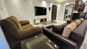 Una sala de estar moderna con sofá, mesa de centro y televisor de pantalla plana.