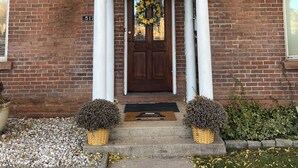 A brick building with a white porch, a decorative door, and a wreath. - Family Getaway! Book this home w/ 3 bedrooms/8 beds near Park City! (Heber City)