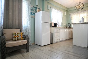 Eine Küchenzeile mit Kühlschrank, Mikrowelle und Spüle.