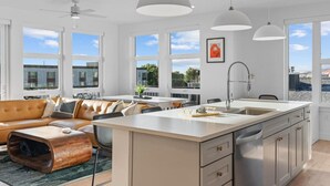 A modern kitchen with a central island, large windows, and a view of the sea. - Superb NEW 2BR amazing amenities (Salt Lake City)