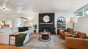 Uma sala de estar moderna com lareira, uma mesa de centro redonda e sofás de couro.