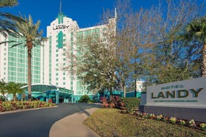 Un hôtel avec une enseigne bien visible indiquant « HÔTEL LANDY » et « ORLANDO UNIVERSAL BLVD. ».