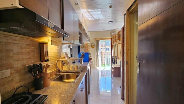 A modern kitchen with a granite countertop, stainless steel sink, and a built-in oven. - Studio - Sleeps 4 - Pets - Smoking - Wifi (Baguio)