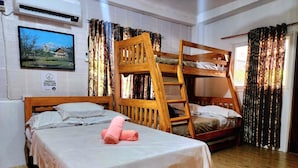 A room with two wooden bunk beds, a single bed, a wooden ladder, and a bed with pink towels. - 3 Bed House - Sleeps 20 - Pets - Pool - Garden (La Union)