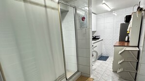 Een badkamer met toilet, wastafel en douchehoek.