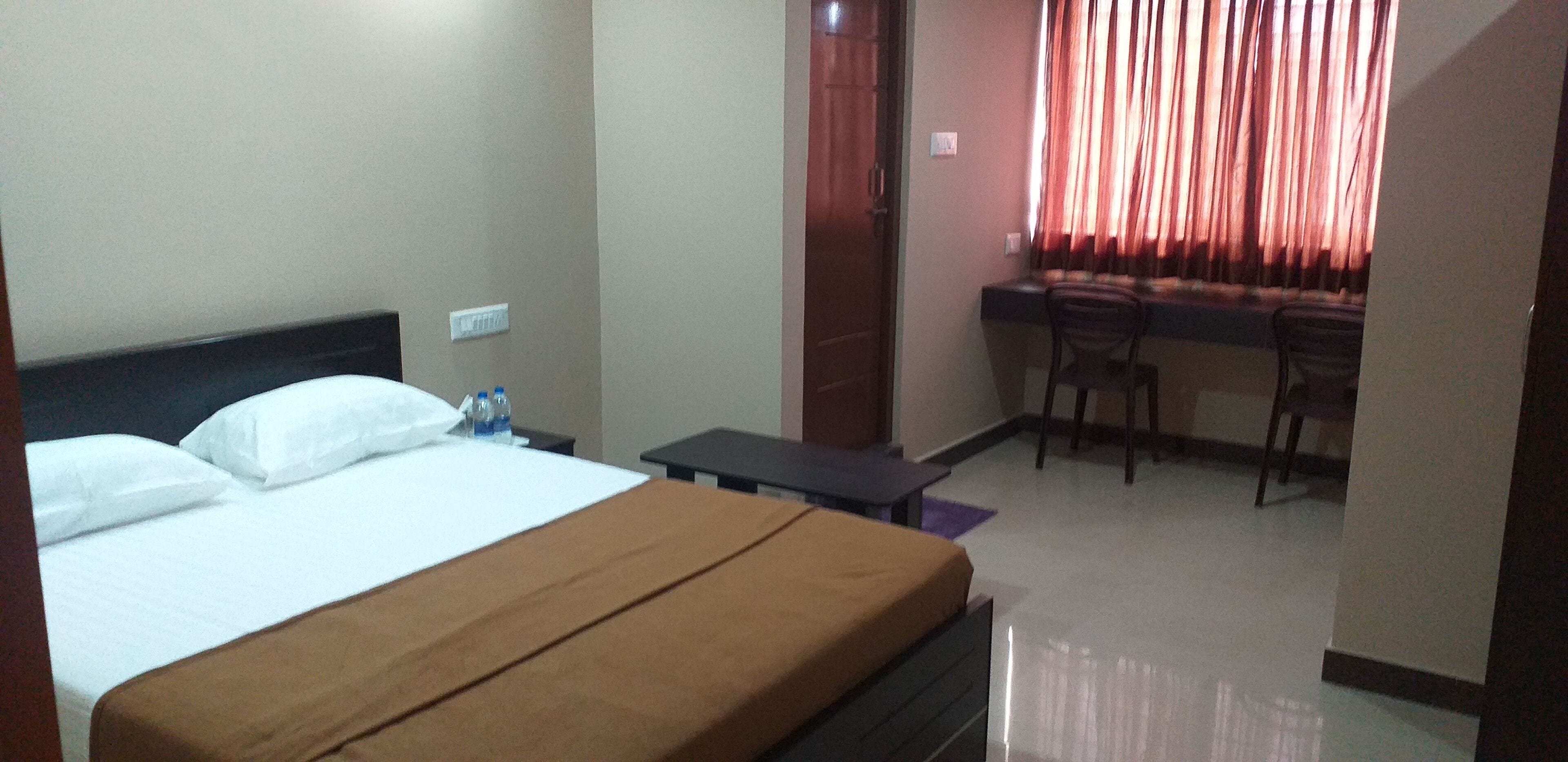 A hotel room with a bed, a desk, and a chair.