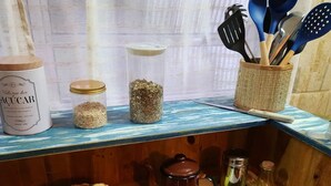Eine Küchenarbeitsplatte mit einer Zuckerglas, einer Kaffeekanne, einem Kuchen und einer Schale Brownies.