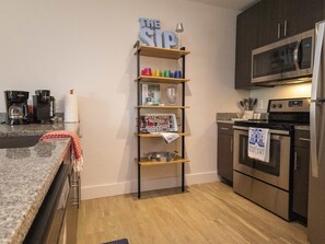 A modern kitchen with a coffee maker, microwave, and stainless steel appliances. - Golding Era at 514 Jackson (Oxford)
