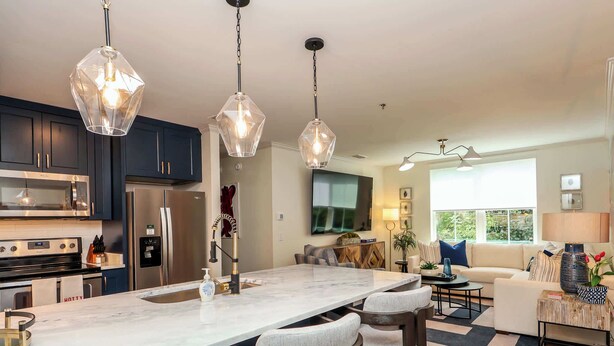 A modern kitchen with dark cabinets, a large island with bar stools, stainless steel appliances, and pendant lighting. - Within Punting at 514  by Apex Short Term Stays (Oxford)