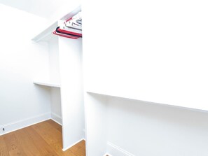 A white closet with hanging space and a wooden floor. - Sip Sanctuary by Apex Short Term Stays (Oxford)