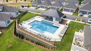 Un quartier résidentiel comprenant plusieurs maisons, une piscine et un patio couvert.