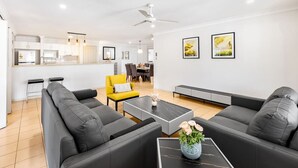 A modern living room with a sofa set, a coffee table, and a yellow chair. There is a kitchen area in the background with a dining table and chairs. - Peaceful 4B2B Sweet Home w/Backyard @ Springfield (Springfield)
