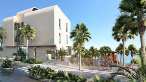Un bâtiment moderne dot é d’un toit plat, de grandes fenêtres et d’un espace paysager agrémenté de palmiers et d’arbustes.