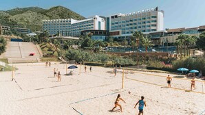 Un terrain de beach-volley avec un hôtel en arrière-plan.