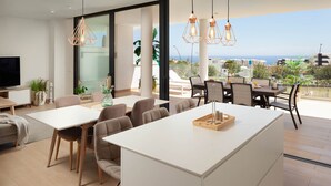 Une cuisine moderne dotée d’un îlot central, d’un coin repas avec des chaises et d’une vue sur la mer.
