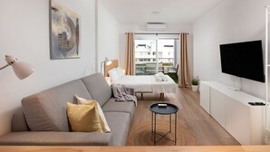 A modern hotel room with a sofa, a bed, a small table, and a TV. - Miraflores Refurbished by Alfresco Stays (Mijas Costa)